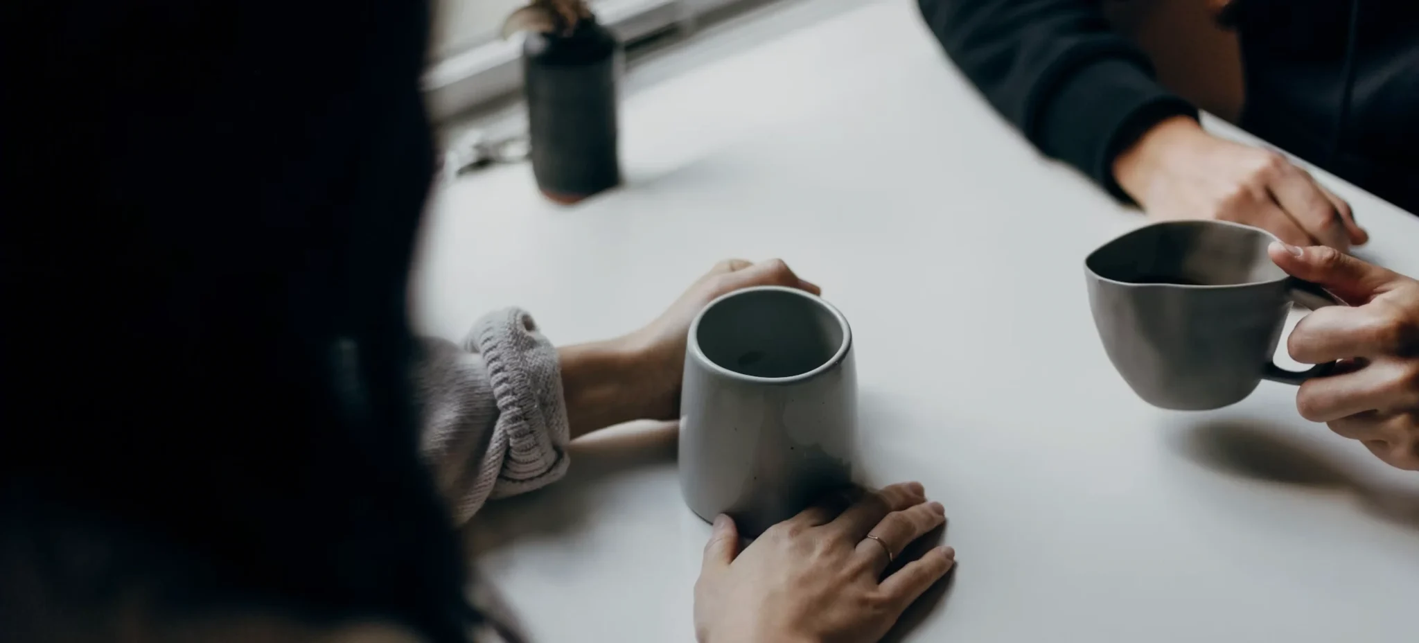 Two people talking over coffee during a private consultation