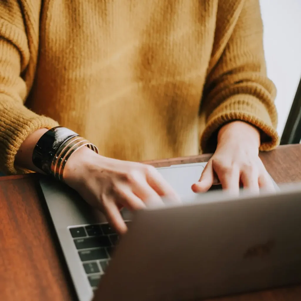 Person using a laptop at home to access an online therapy session