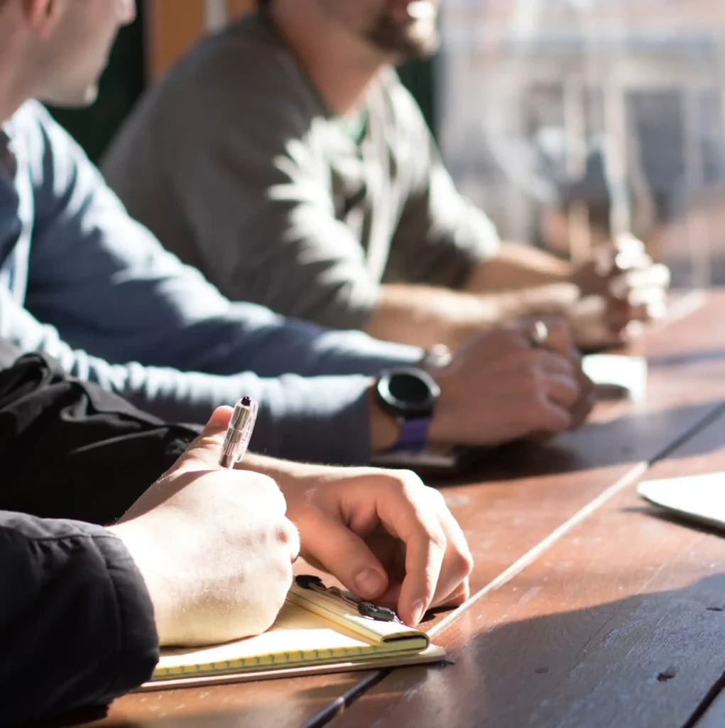 Professionals taking notes and sharing ideas during a group discussion