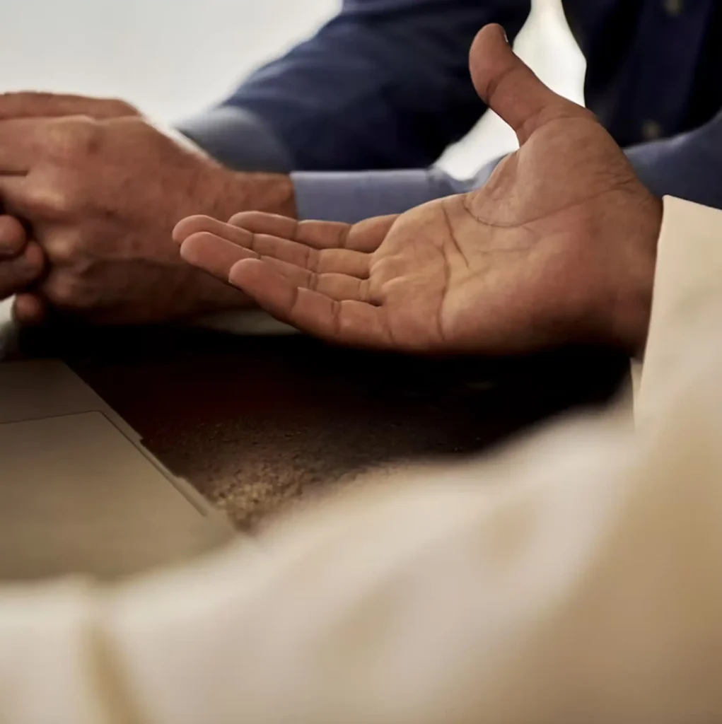 Close-up of two people using hand gestures during a supportive therapy conversation
