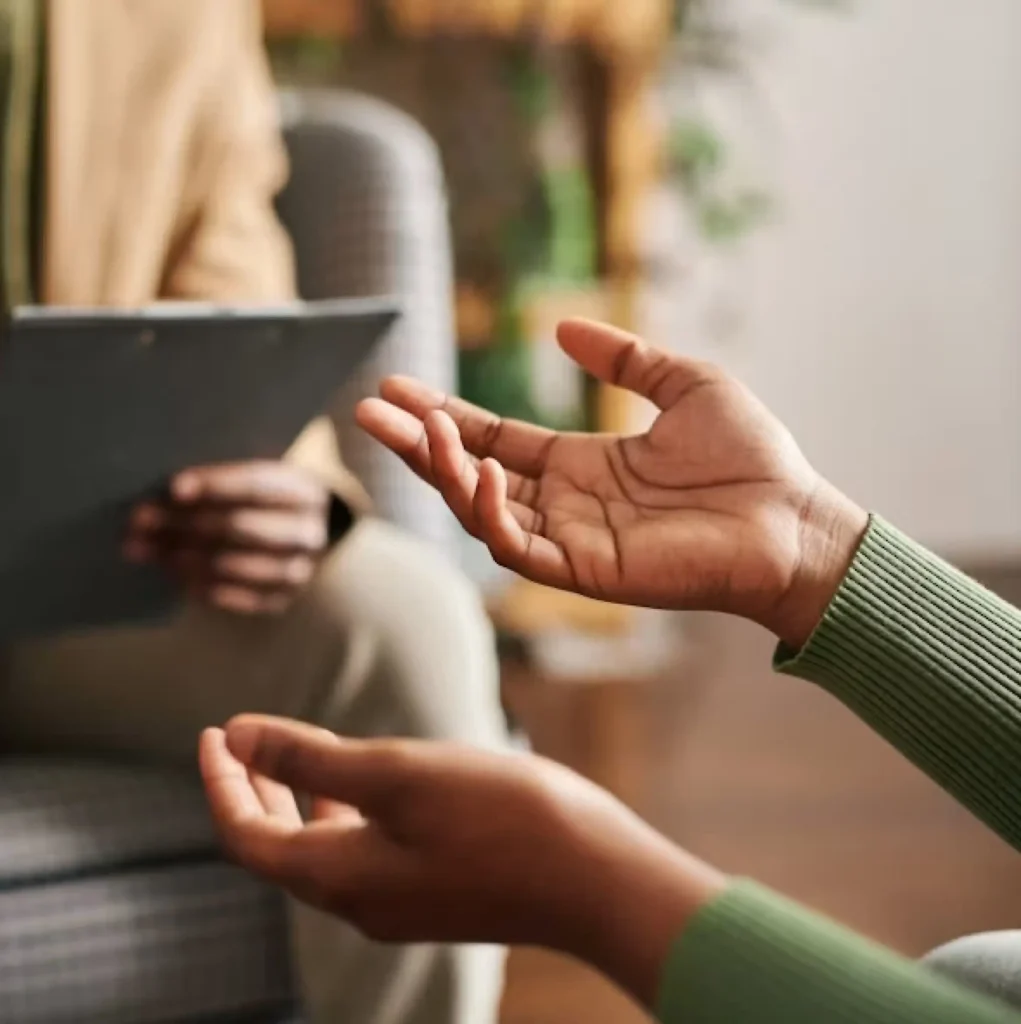Therapist holding a tablet while listening to a client during a session